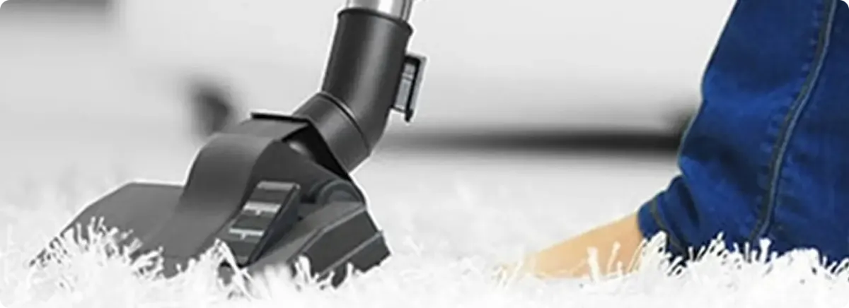 Close-up of a professional vacuuming a white carpet in Edwards.